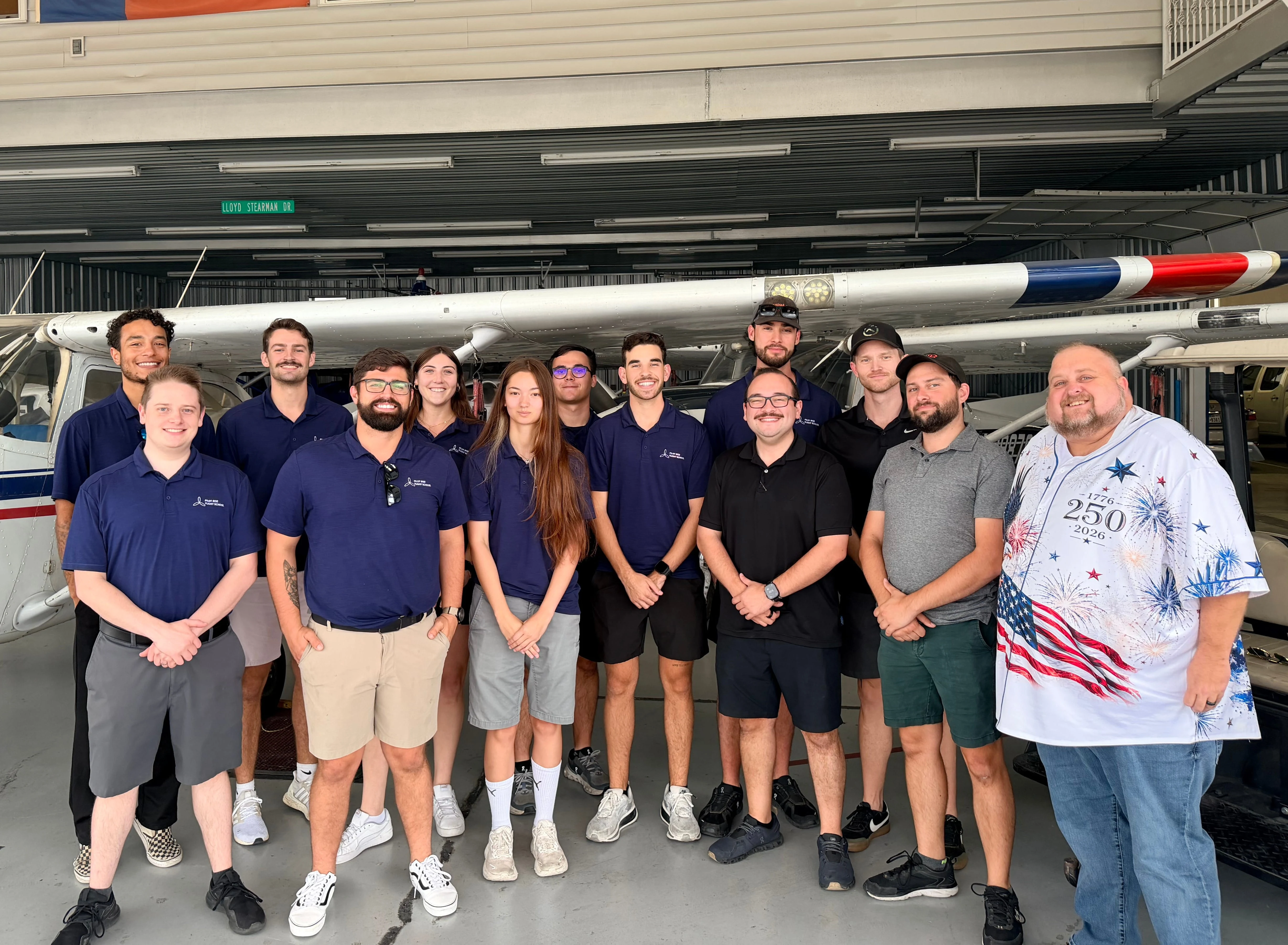 Pilot Rise team from the Dallas and Fort Worth flight schools gathered together in an aircraft hangar