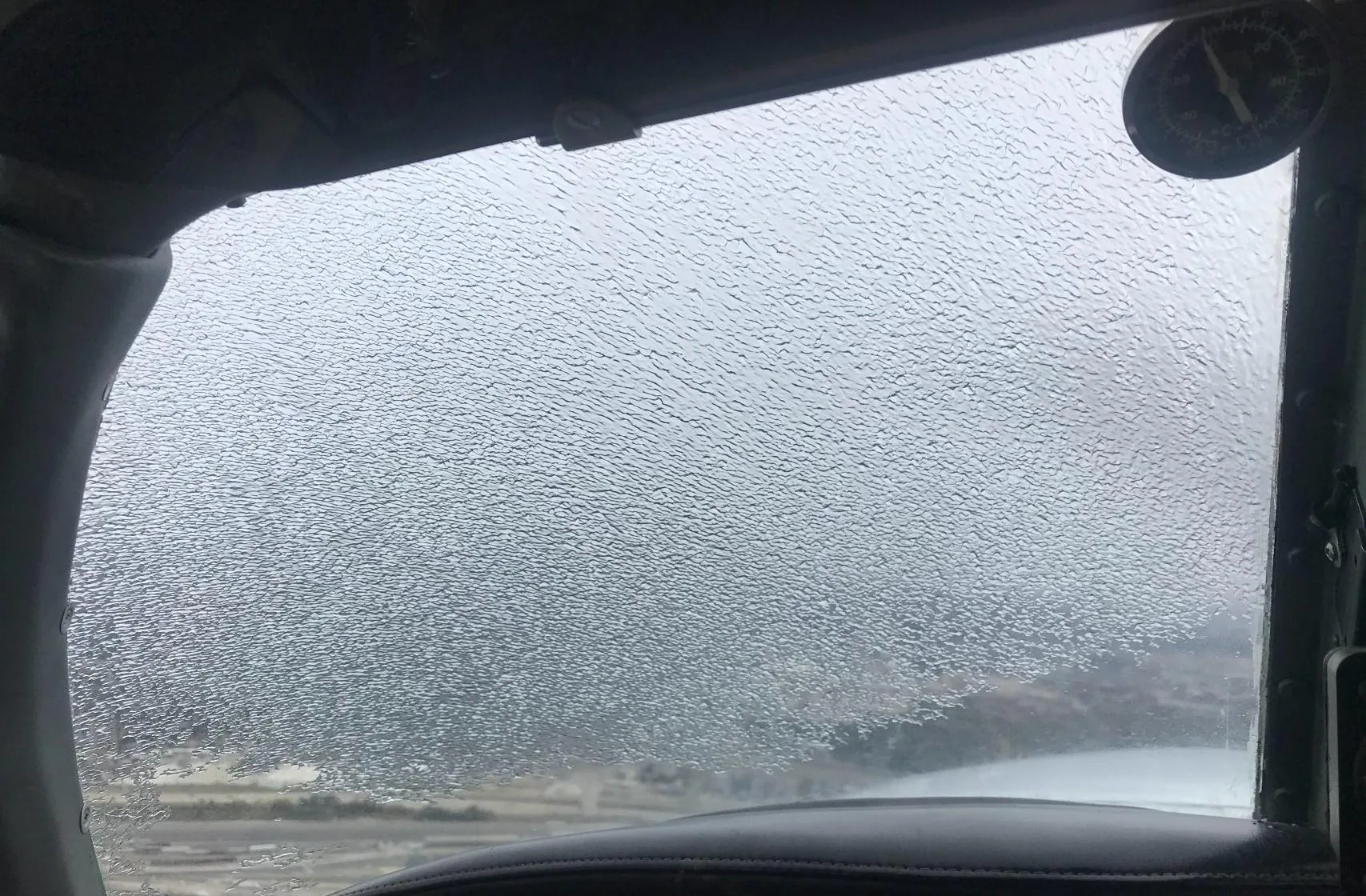 Aircraft window covered in ice
